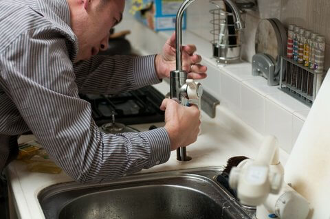 plumber fixing leaking tap